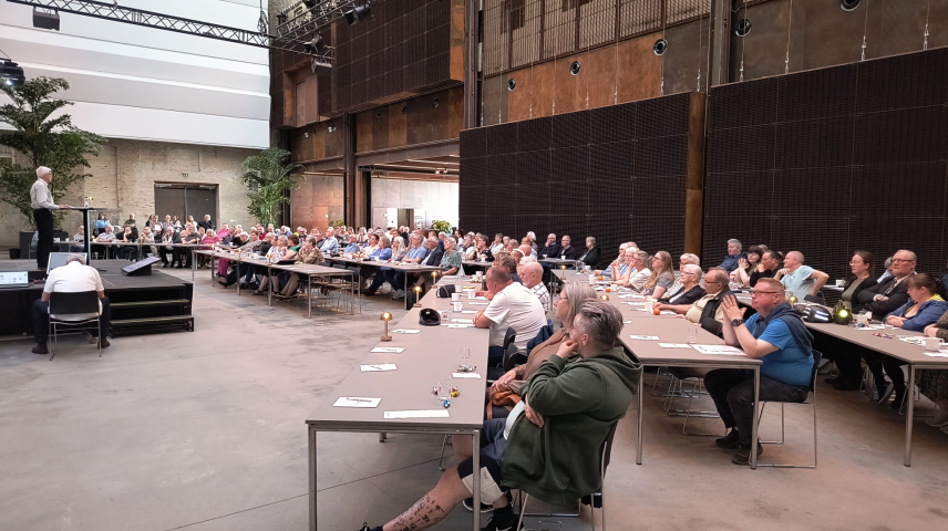 Billedet viser bestyrelsesmøde hvor formanden taler på scenen