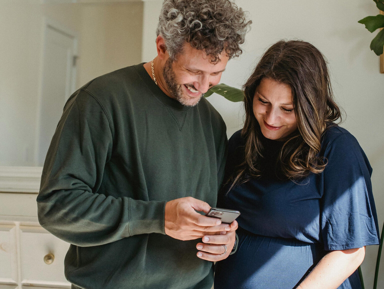 Billedet viser en mand og kvinde som kigger på mobil